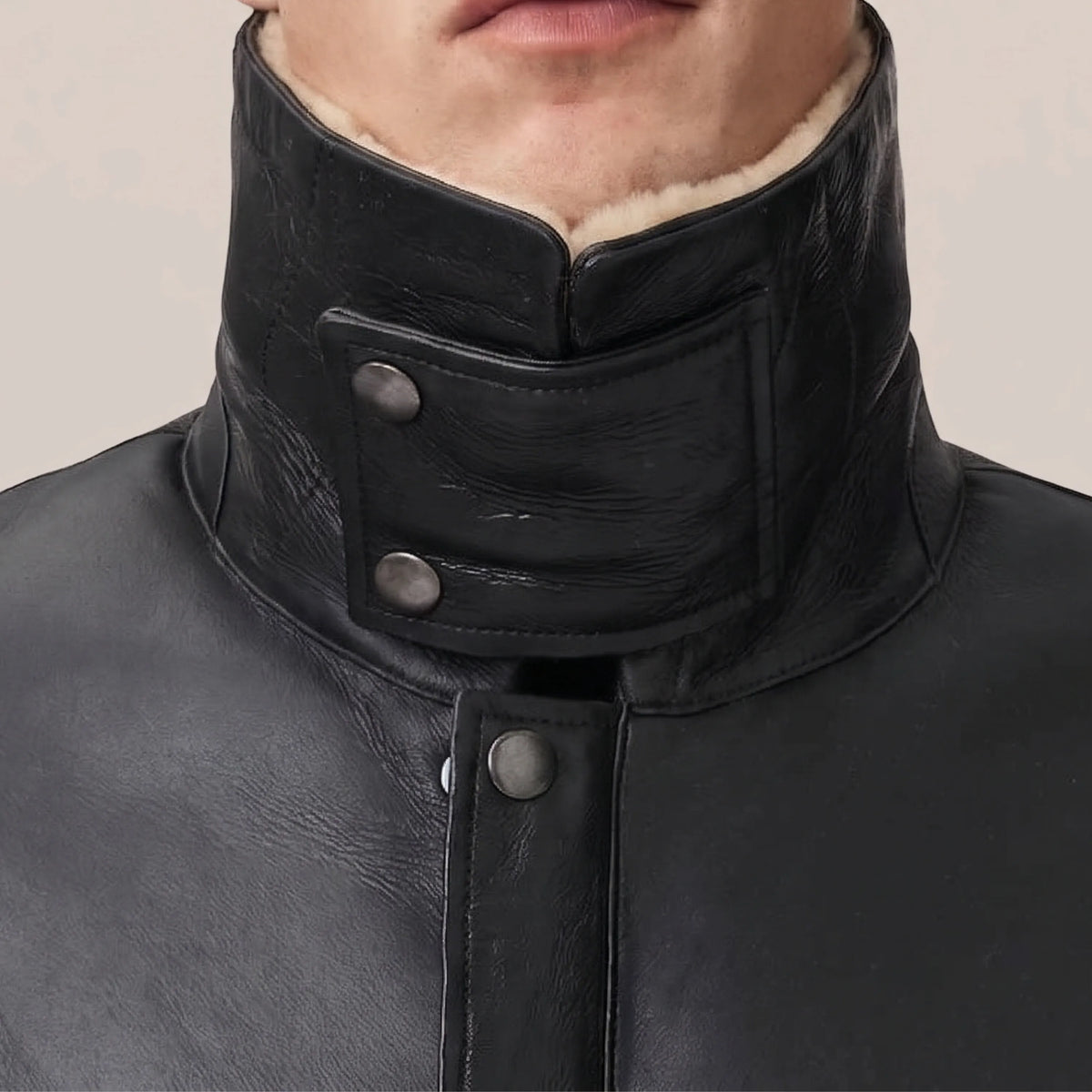 Snap-button and zip closure on black shearling leather coat