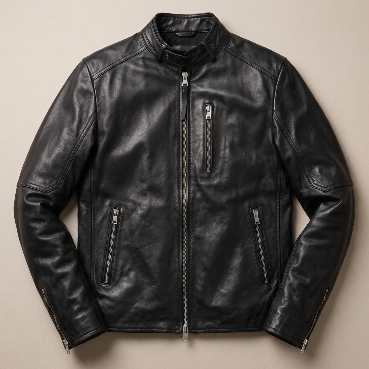 Jet black leather jacket with snap collar worn with dark jeans, full-length view
